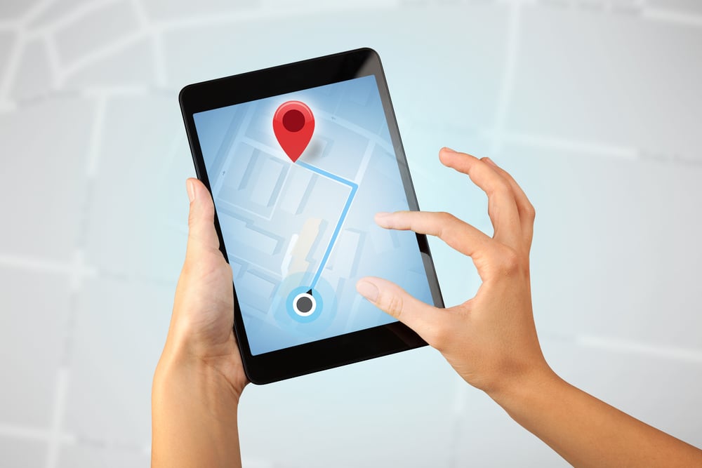 Female fingers touching tablet with map