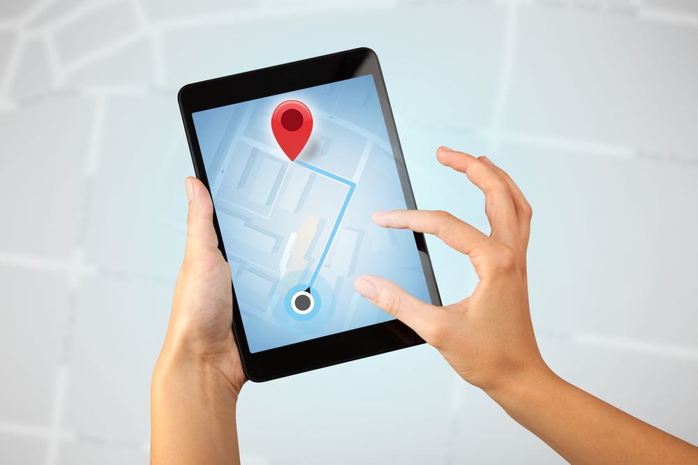 Female fingers touching tablet with map Female fingers touching tablet with map